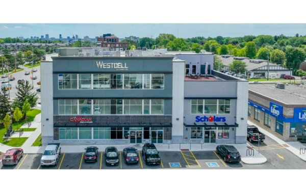 Street-level view of the Hyland Office Building in Ontario, Canada, with storefronts.