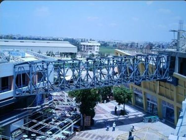 Aerial view of a cinema entertainment center connected by a long steel bridge.
