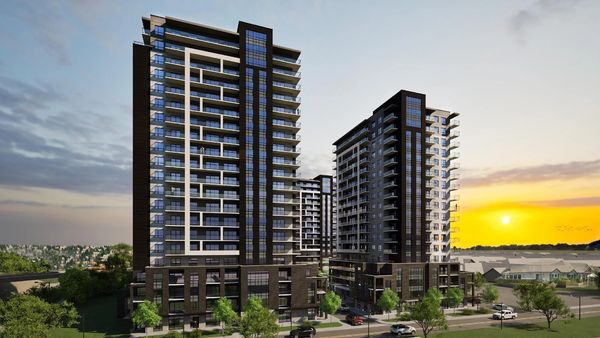 Modern multi-story residential buildings with balconies and large windows at sunset.
