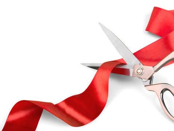 Scissors cutting a red ribbon.