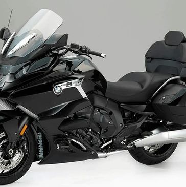 Black BMW touring motorcycle with windshield and side cases.