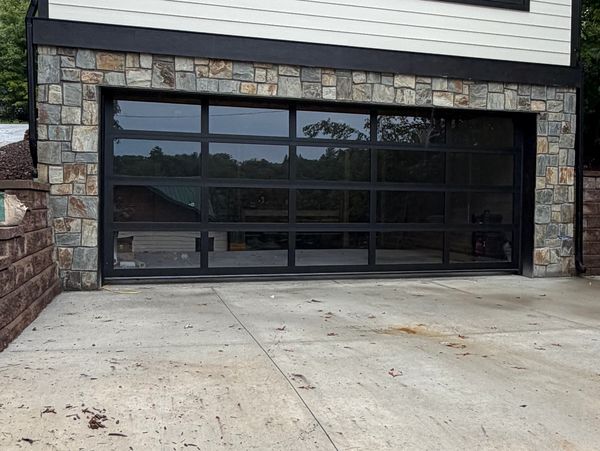 Modern glass garage door with stone frame.