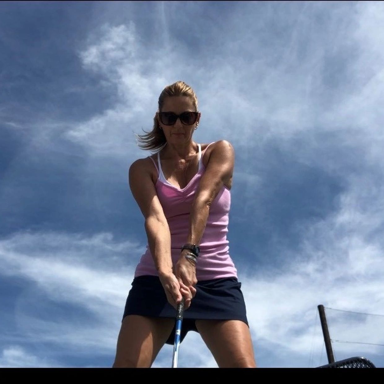Sherry Locke  holding a golf club preparing to swing.