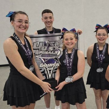 Cheerleaders holding a champion trophy.