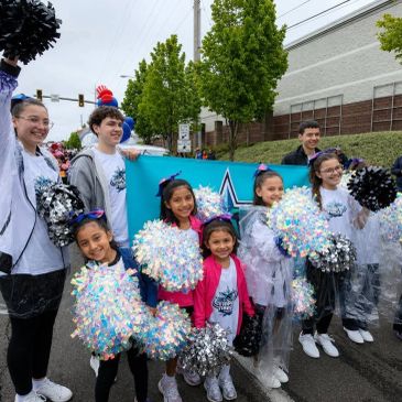Cheerful group of cheerleaders posing with pom-poms during an outdoor event.