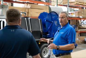 Two men conversing in a warehouse.
