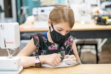 Girl learning to sew with the sewing machine 