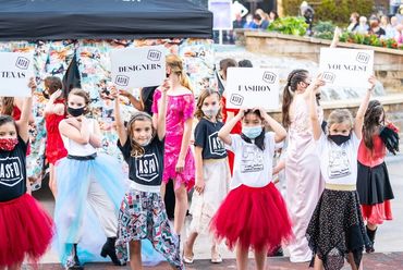 Group of girls with signs at their fashion show event 