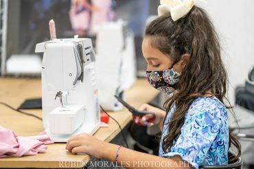 Girl with her sewing machine in summer camp 