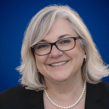 Smiling woman with gray hair and glasses.