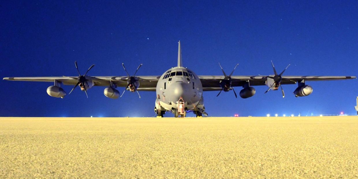Front view of a large military cargo aircraft on runway at night.