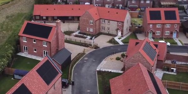 Residential houses with solar panels on roofs.