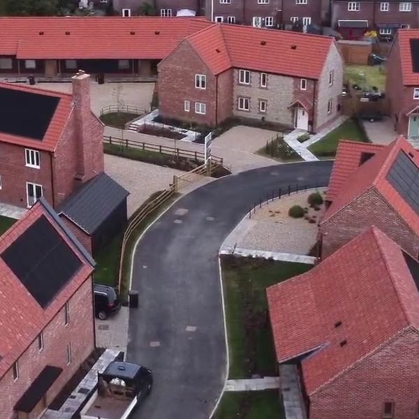 Residential area with red-roofed houses and a curved road.