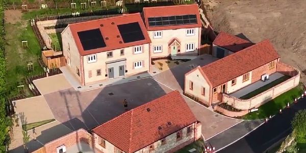 Aerial view of a small residential area with solar panels on roofs.