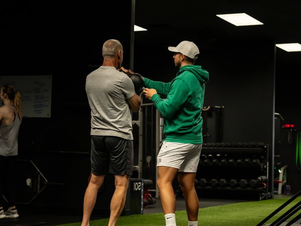 Certified personal trainer coaching a client through a training session at our  gym in Tulsa.