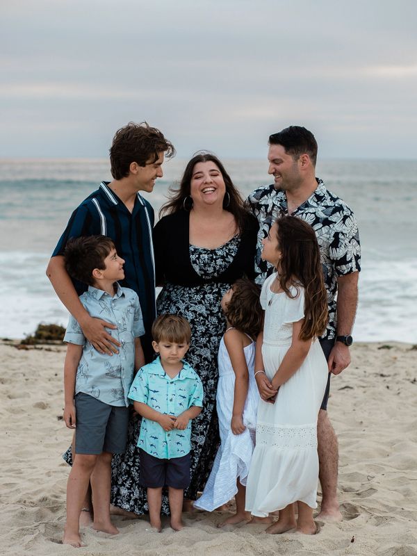 A happy family of seven enjoying a day at the beach together.
