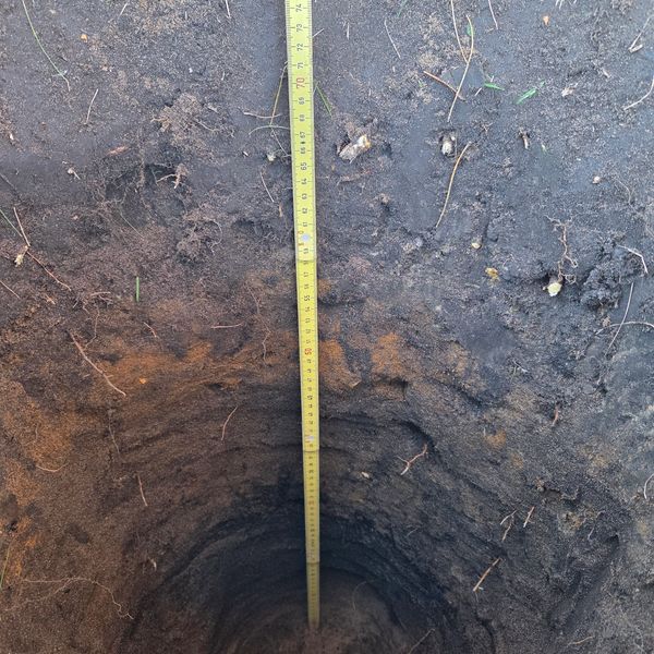 A shovel test penetrating through fill to a buried archaeological feature.