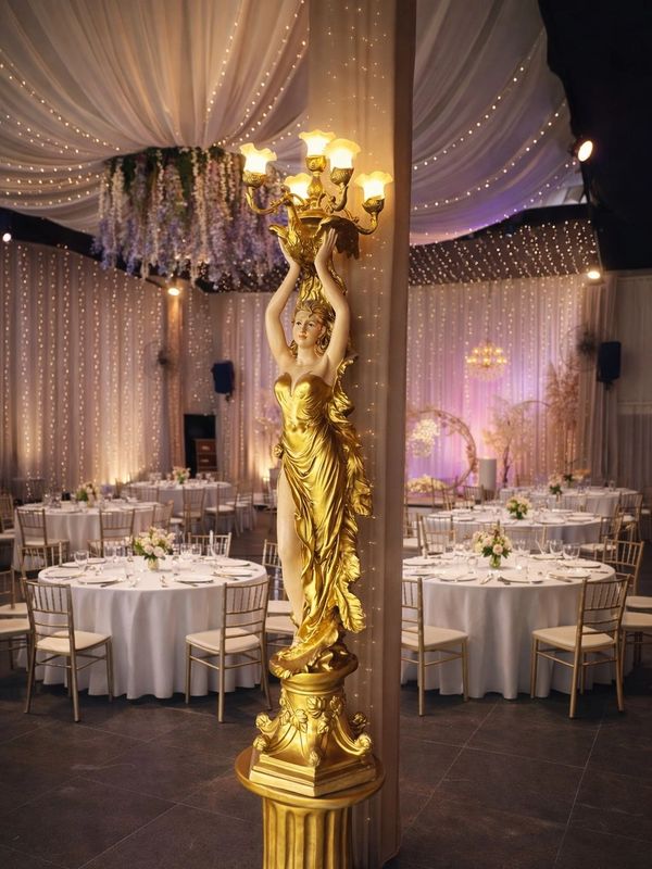 Elegant golden statue lamp in a beautifully decorated banquet hall.