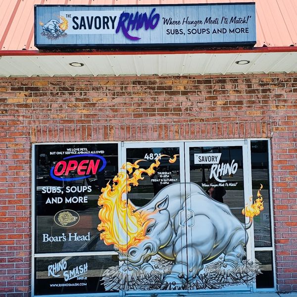 The Savory Rhino sandwich shop with a fiery rhino mural on its entrance doors.