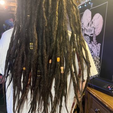 Long dreadlocks adorned with beads and rings.