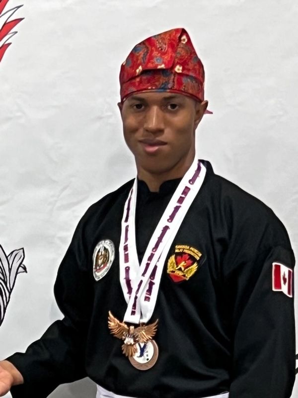 Man wearing a traditional hat and sports medal.