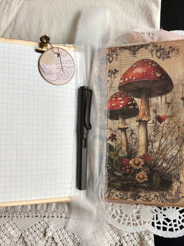 Open notebook with graph paper and pen, beside mushroom illustration.