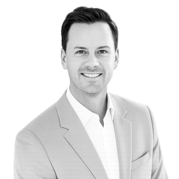 Smiling man in light suit jacket and white shirt.