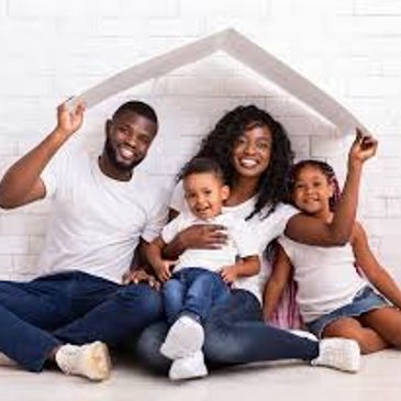 Happy family of four sitting together under a roof-shaped frame.