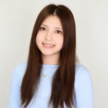 Young woman with long brown hair smiling.