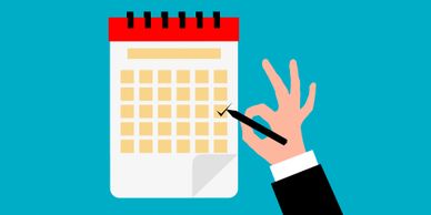 Hand marking a date on a calendar with an OK gesture.