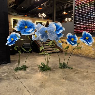 Large blue artificial flowers in an indoor modern space.