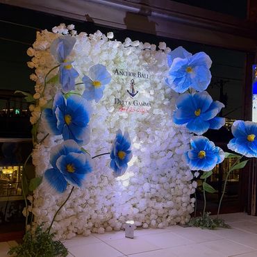 Decorative white flower wall with large blue flowers for Anchor Ball event.