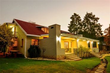 A cozy house with warm lighting at dusk.