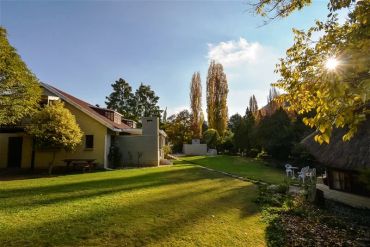 Peaceful backyard with a house and garden in sunlight.