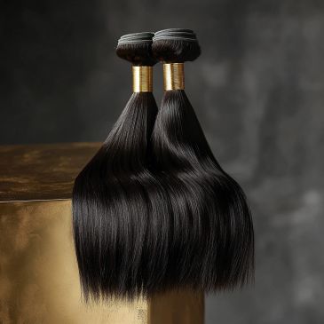 Two bundles of sleek, shiny black hair extensions with golden bands.