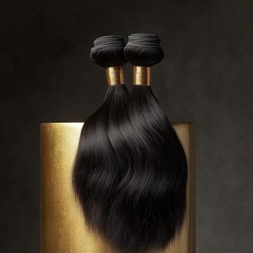 Two bundles of sleek, black hair extensions with golden bands, displayed on a gold pedestal.