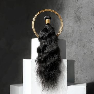 Long, wavy black hair bundle displayed with gold ring on white blocks.