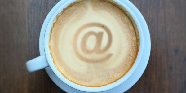 Coffee With Email Logo In On A Wooden Desk