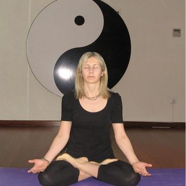 Yoga yapan kadın meditatif pozisyonda oturuyor.