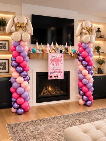 Easter bunny-themed party decorations with balloon columns and stuffed bunnies.