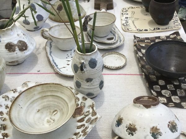 Handcrafted pottery pieces displayed on a cloth.
