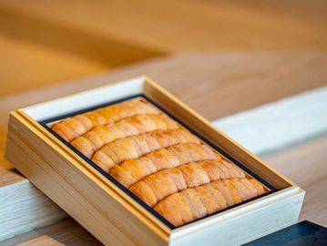 Box of fresh uni (sea urchin) on wooden table.