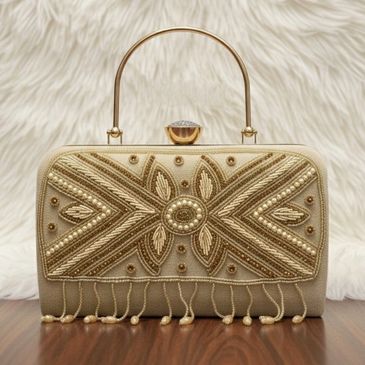 Tracky Trendz showcases a regal clutch with gold embroidery, pearl accents, and tassels—perfect for 