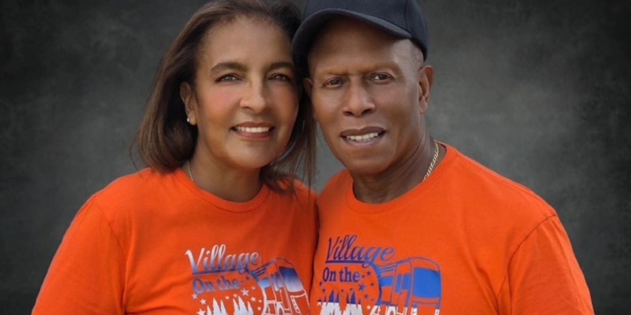 Couple wearing matching orange t-shirts smiling at the camera.