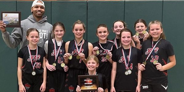 Youth basketball team with medals and championship plaque.