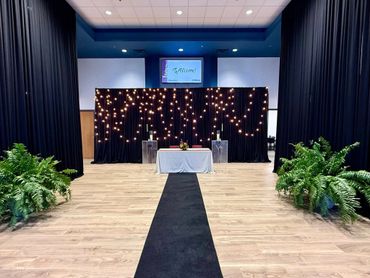 Elegant event setup with string lights and greenery.