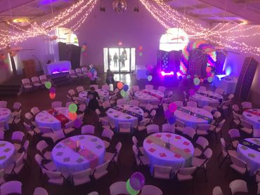 Indoor party setup with tables and balloons.