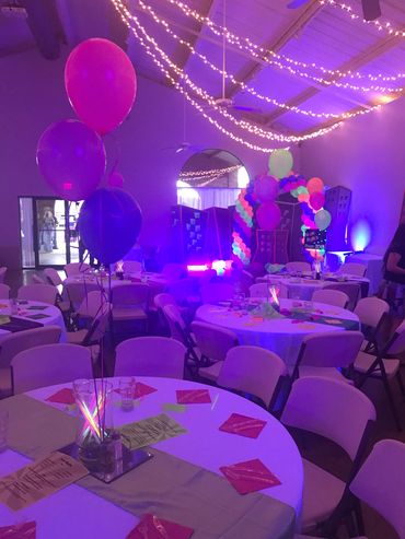 Decorated room with balloons and lights for a party.