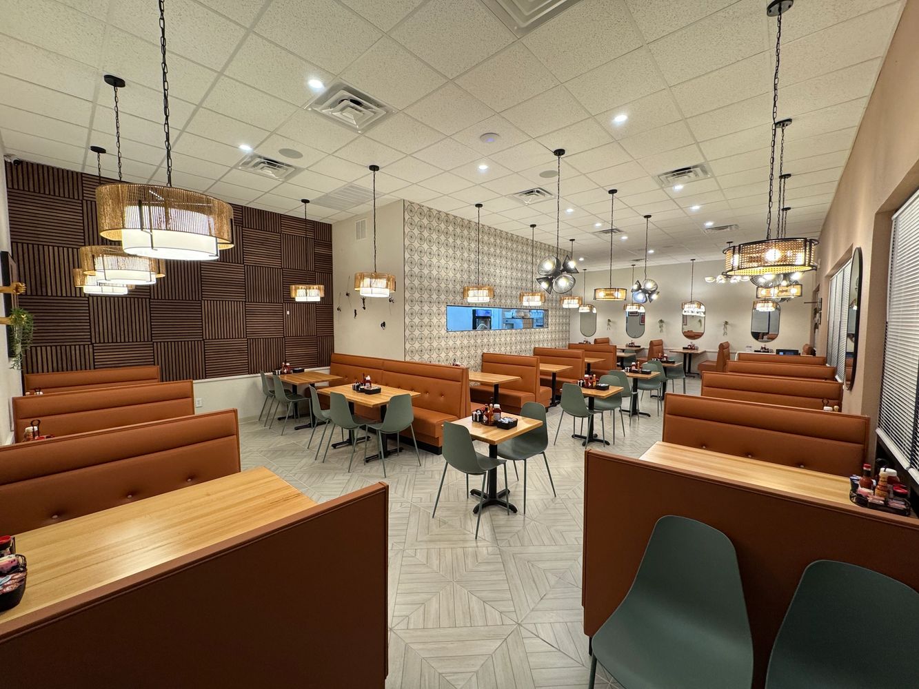 Modern restaurant interior with brown booths and pendant lighting.