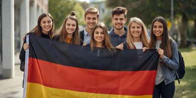 Group of young people holding a German flag outdoors.